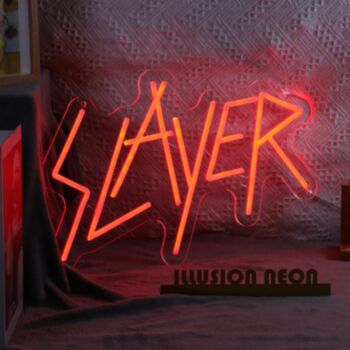 "The Slayer Neon Sign is a bold and vibrant piece of neon art that captures the attention of anyone who sees it. The sign features the word "Slayer" in bright, neon red, with a fierce and fierce font that commands respect. The letters are surrounded by a 