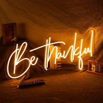 The Be Thankful Neon Sign is a bright and vibrant piece of decor that is perfect for adding a touch of positivity to any room. The bold orange letters are filled with neon light, creating a striking and eye-catching display. The sign is mounted on a sleek